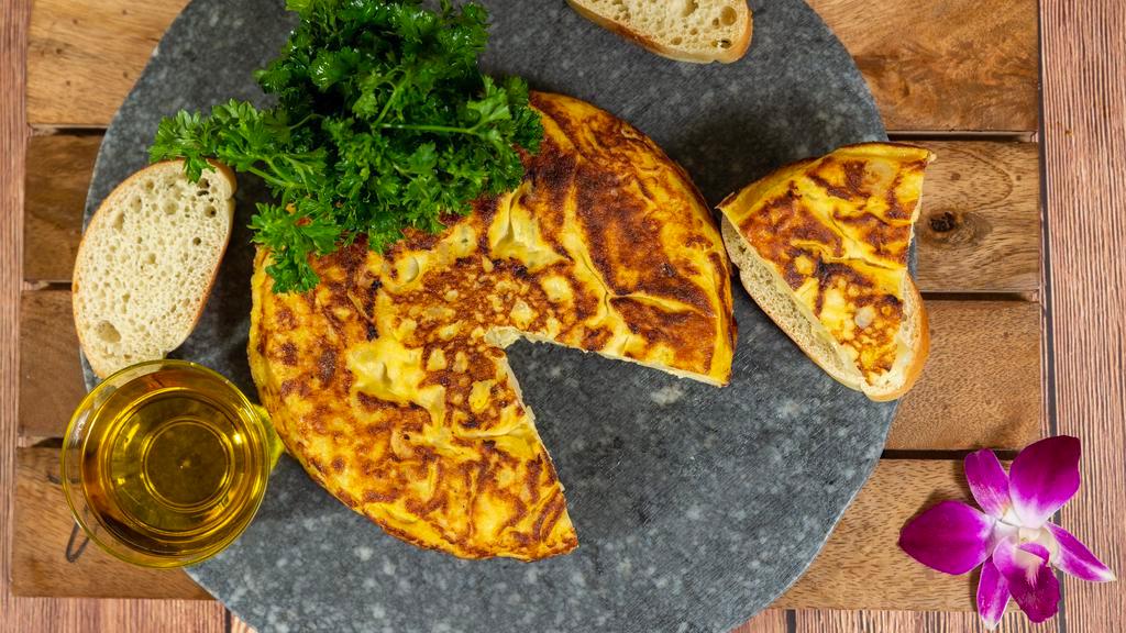 Tortilla Espanola · Traditional Spanish omelet with potatoes served with mojo picon.
