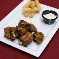 Masitas de Cerdo con Papas Fritas · Pork wings with fries or tostones.