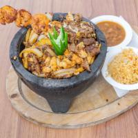 Texas Molcajete Plate · Shrimp, chicken, skirt steak and Mexican chorizo cooked with onions and mozzarella cheese.