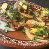 Al Pastor Taco · Pork marinated with spices and citrus then topped with pineapple.