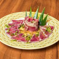 Tuna Tataki · Lightly seared tuna tataki served with ponzu sauce, scallions, and sesame seeds.