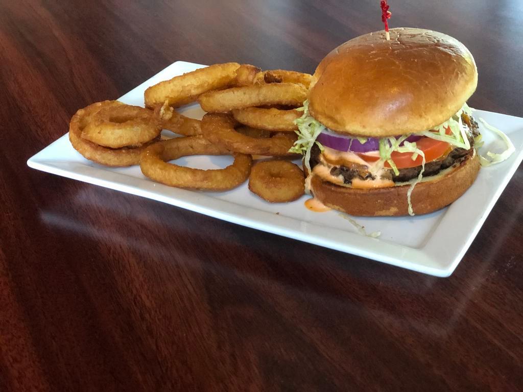Social Burger · Topped with melted Gouda cheese, lettuce, tomato, onion, and house-made Sriracha ranch dressing. Served on a toasted brioche bun.