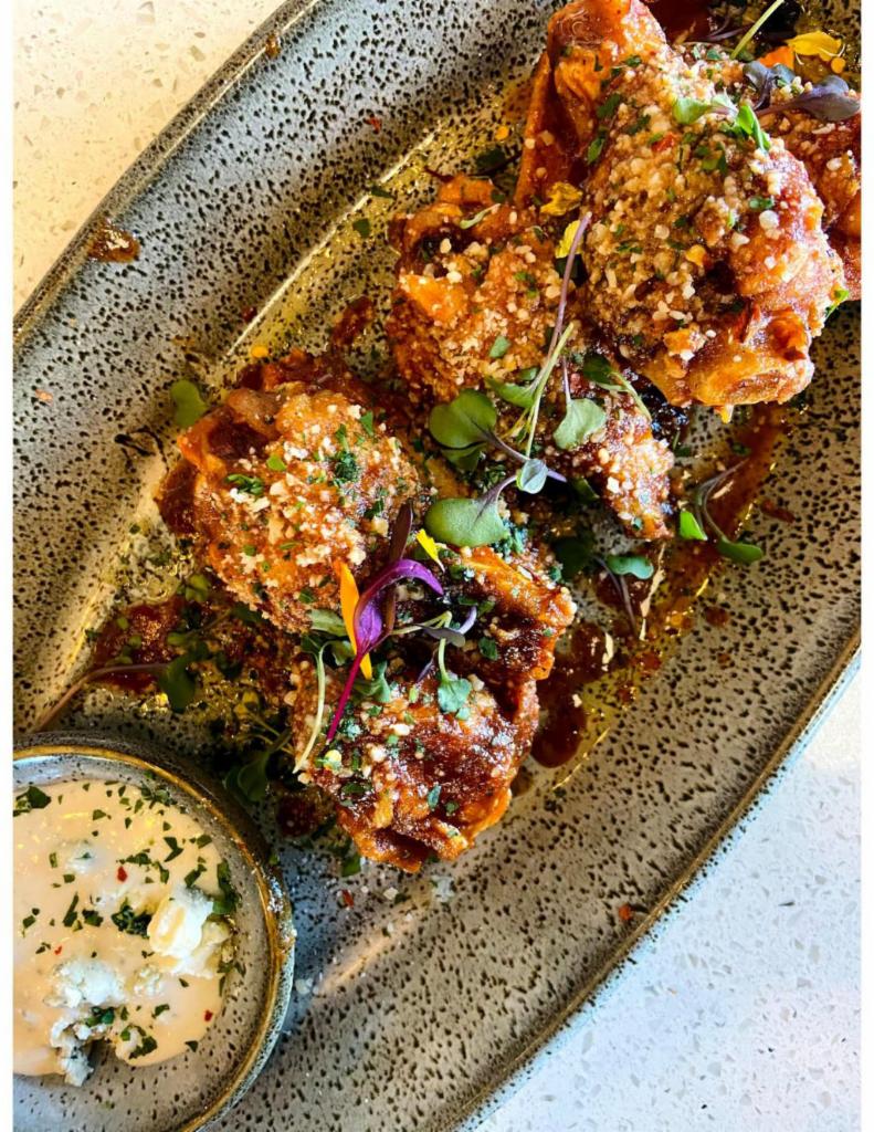 Chicken Wings Plate · Homemade tangy BBQ sauce, chili oil, Parmesan, blue cheese.