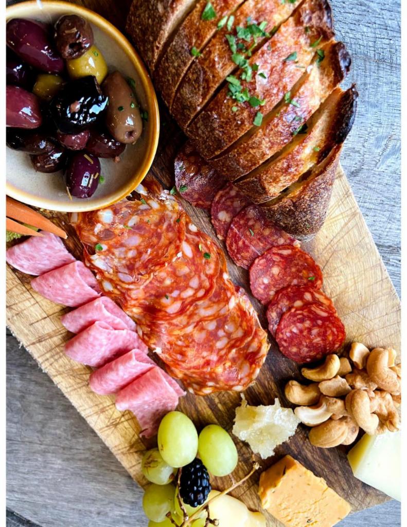 Ambassador Board Plate · Selection of 3 pieces artisanal cheeses and meats. Served with compotes, pickled vegetables, honey, nuts, fruit, toasted baguette, whole grain mustard, marinated olives.