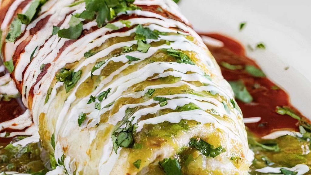 Bandera Burrito · Think super burrito but with red guajillo sauce and green tomatillo sauce smothered on top with sour cream down the center burrito.
