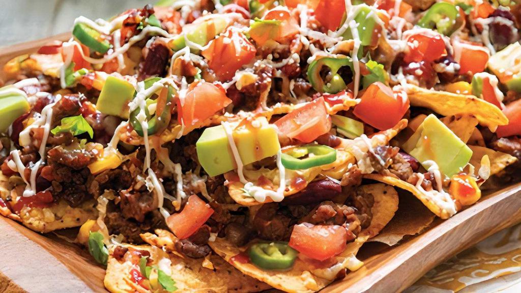 Super Nachos · Corn tortilla chips, nacho cheese, jalapenos, beans, pico, sour cream, avocado, and your choice of meat.
