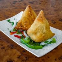 Samosa · 2 pieces. Veggie turnover, stuffed with potatoes, green peas, herbs and spices, served with ...