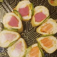 14. Love Triangle Roll · Salmon, yellowtail and tuna wrapped in soy paper topped with wasabi truffle aioli and Srirac...