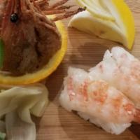 Ama Ebi Nigiri · Two pieces of raw sweet shrimp over sushi rice with fried heads on the side.