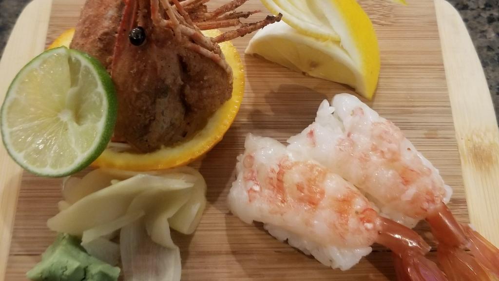 Ama Ebi Nigiri · Two pieces of raw sweet shrimp over sushi rice with fried heads on the side.