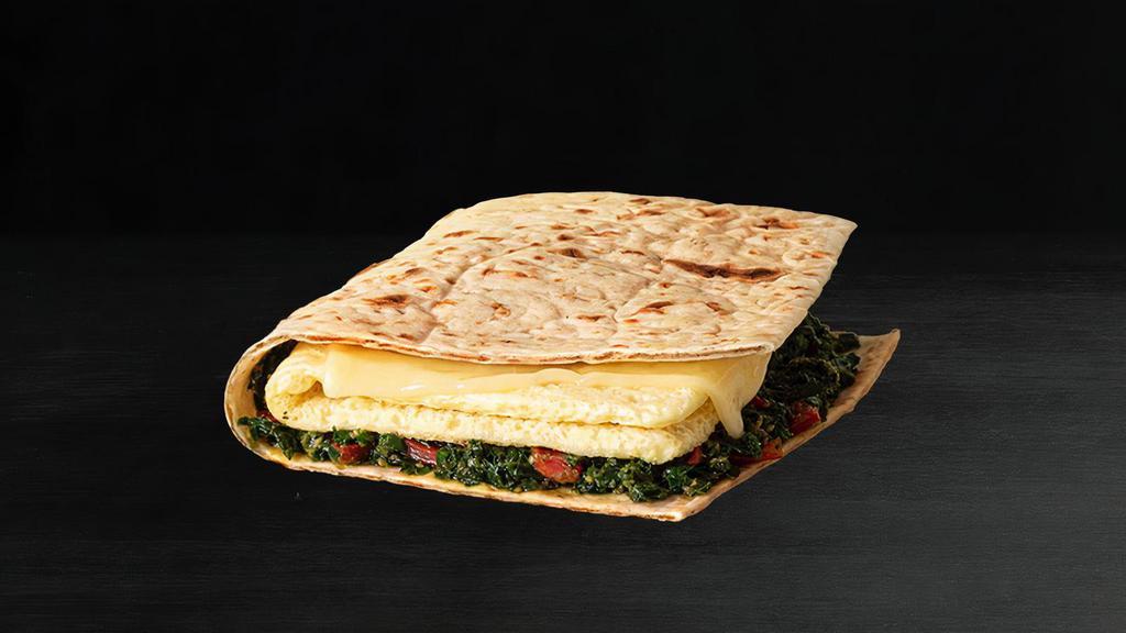 Plant-Based Mediterranean Flatbread · A fully plant-based flatbread with JUST Egg™ and Violife® 100% Vegan cheese atop a savory blend of vegan pesto, kale, tomatoes, and tangy bell peppers inside a crispy lavash. Available all day.