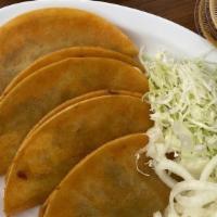 Taco de canasta Chicharron · corn tortilla soft taco stuffed with pressed pork.
Toppings on the side: Onions and cabbage.