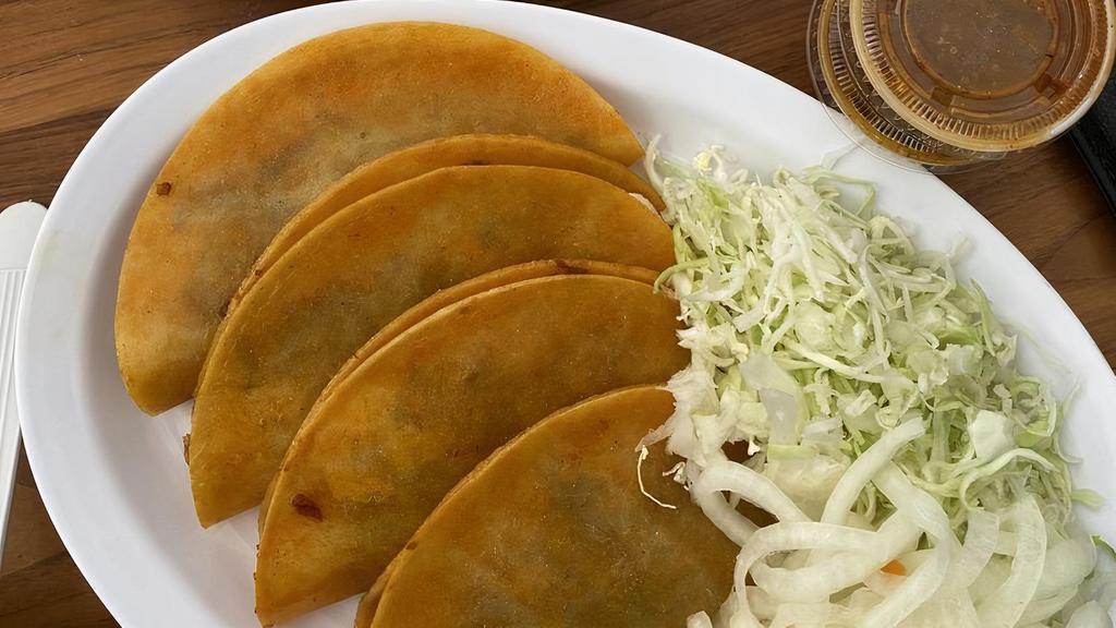 Taco de canasta Chicharron · corn tortilla soft taco stuffed with pressed pork.
Toppings on the side: Onions and cabbage.