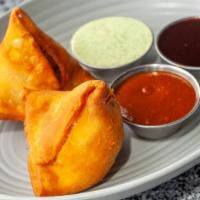 Samosas · Two crisp vegetable puffs filled with potatoes peas and spices.