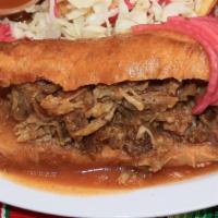 Torta Ahogada · Mexican Sandwich, with beans and carnitas (deep fried pork) topped with special tomato sauce...