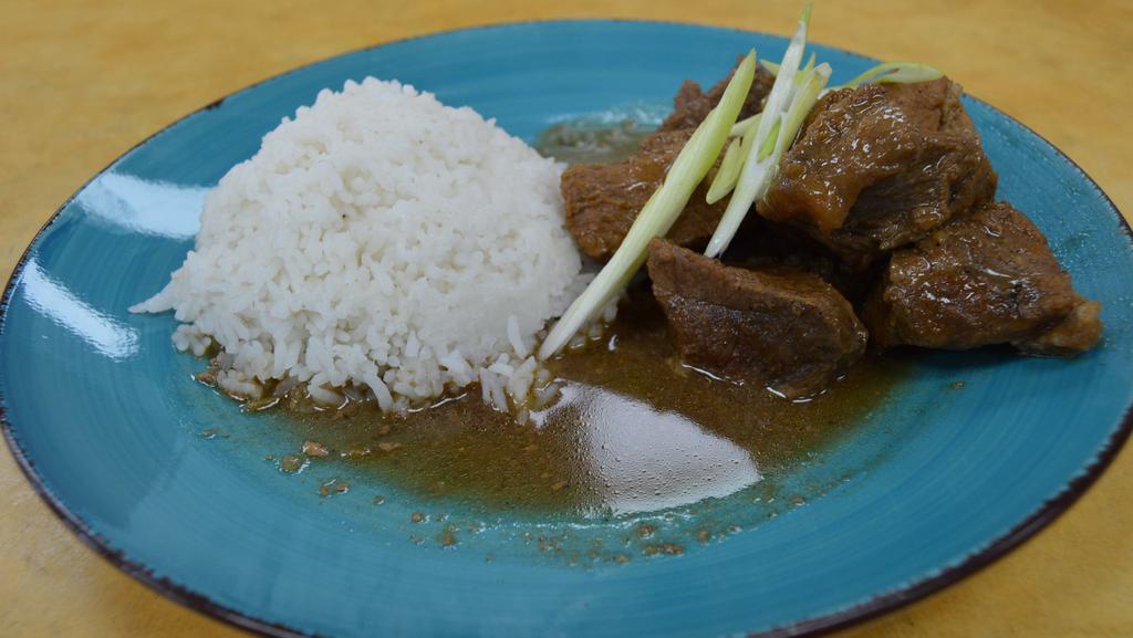 Pork Adobo with Rice · Pork cooked in soy sauce, garlic, and vinegar.