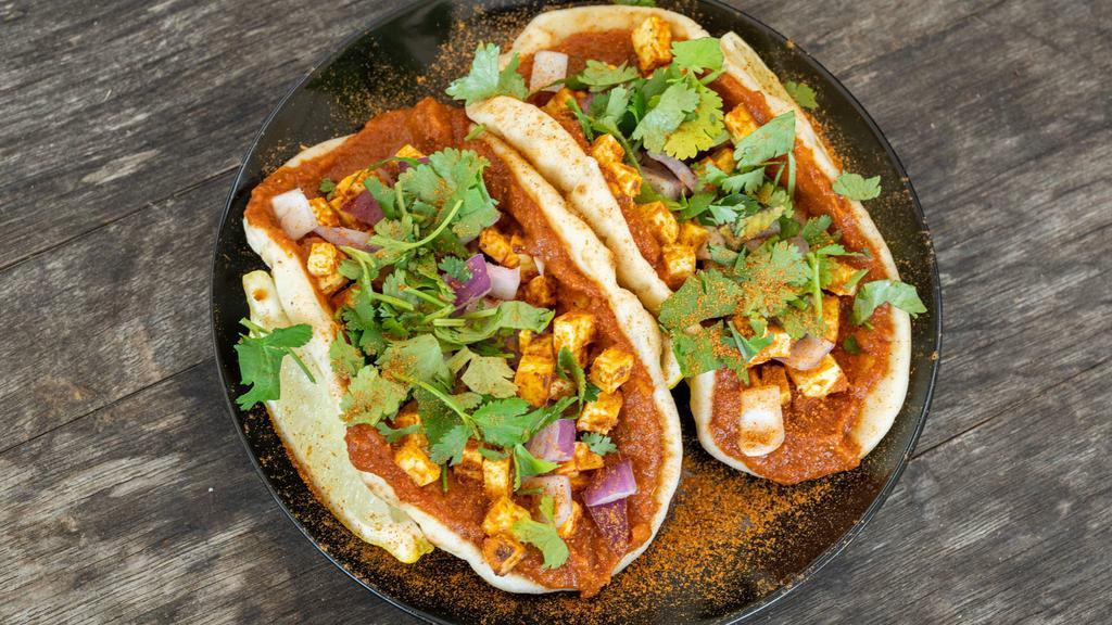 Chili Paneer (Naan Tacos) · Two mini garlic naans with masala marinated paneer, spicy curry sauce, red onions, fresh cilantro and mint chutney.