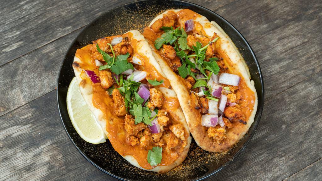 Butter Chicken (Naan Tacos) · Two mini garlic naans with masala marinated chicken, creamy curry butter sauce, red onions and fresh cilantro.