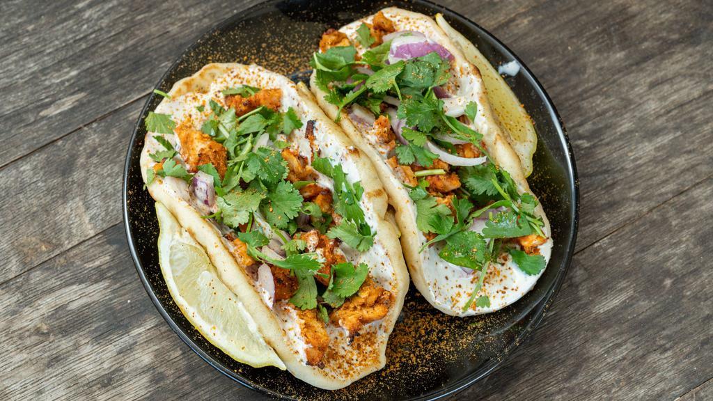 Tandoori Chicken (Naan Tacos) · Two mini garlic naans with tandoori chicken, garlic white sauce, red onions, fresh cilantro and fresh cilantro.