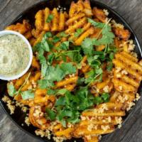Garlic & Masala Fries · Crispy waffle fries seasoned with masala and lemon tossed in garlic and cilantro. Served wit...