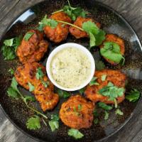Karahi Wings (Bone-in) · Spicy chicken wings marinated in our special dry-rub masala mix topped with lemon and  fresh...