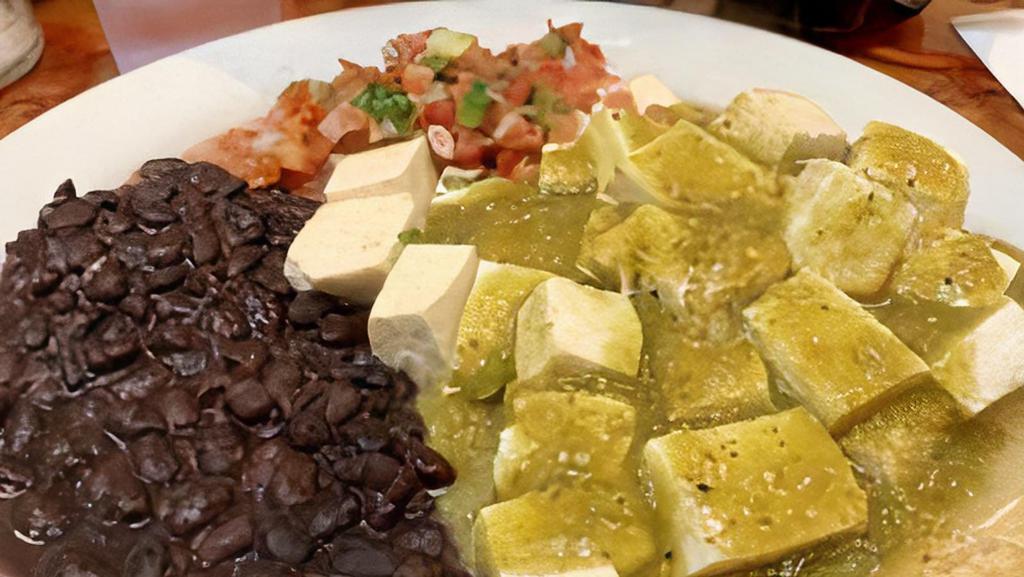 Tofu Rancheros · Vegan. Cubed tofu on two grilled corn tortilla drenched in salsa verde with pico de gallo and black beans.