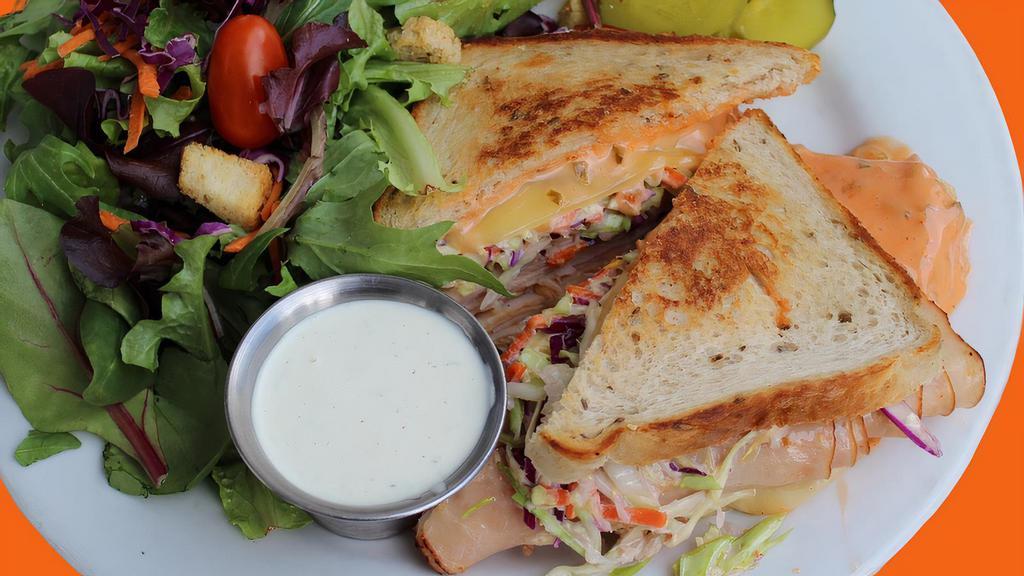 Rudy’s Rachael · Sliced smoked turkey, melted swiss cheese, Thousand island, and coleslaw on grilled rye.