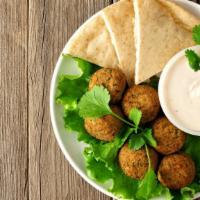 The Falafel Platter · Crispy chickpea balls served with steamed rice, hummus, salad, pita bread and tzatziki sauce.