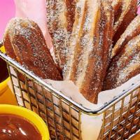 Stuffed Cinnamon Sugar Churros · Chocolate and caramel-filled churros with dipping sauces