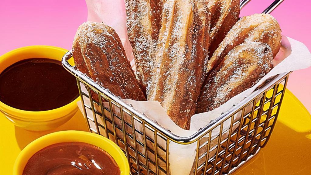 Stuffed Cinnamon Sugar Churros · Chocolate and caramel-filled churros with dipping sauces