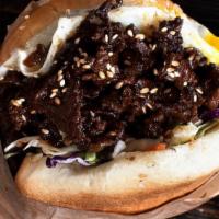 Bulgogi Bun Burger · Korean BBQ beef, over easy egg, soy ginger slaw lettuce , ponzu garlic spread, red sauce, to...