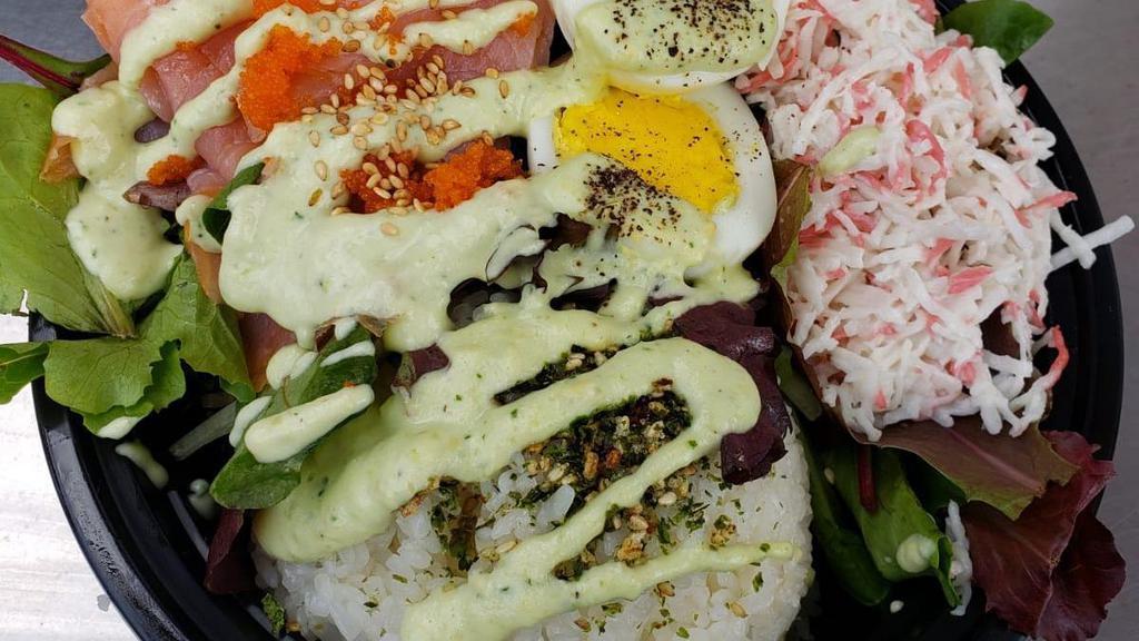 Smoked Salmon Rice Bowl · White rice, furikake, smoked salmon, spring mix, imitation crab, hardboiled egg, masago, topped with roasted sesame seeds and dressing.