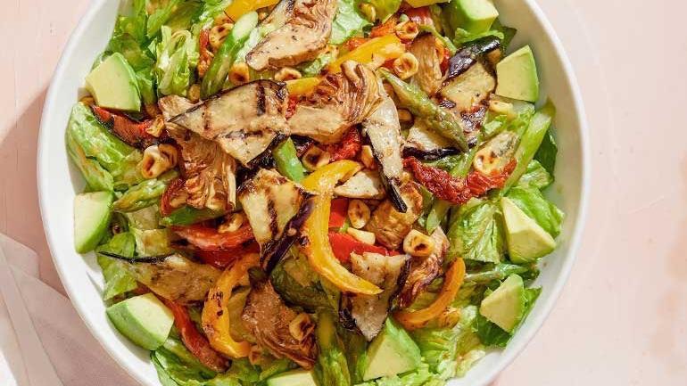 Catering Roasted Veggie Salad · Warm artichoke hearts, asparagus, eggplant, red & yellow peppers, corn and sun-dried tomatoes served with cool Romaine, avocado and housemade Dijon balsamic vinaigrette. Also available with grilled chicken, shrimp or sautéed salmon.