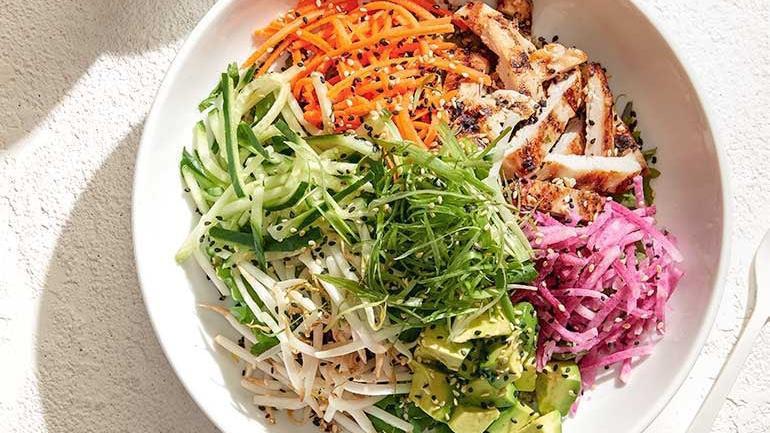 Banh Mi Power Bowl · Quinoa, baby kale, fresh cilantro & mint topped with grilled chicken, watermelon radish, fresh avocado, cucumber, carrot, bean sprouts, scallions and sesame seeds. Served with housemade chili-lime vinaigrette and serrano peppers.