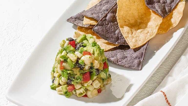 White Corn Guacamole + Chips · Diced avocado, sweet white corn, black beans, jicama, bell peppers, fresh cilantro and serrano peppers. Served with housemade blue & white corn tortilla chips.