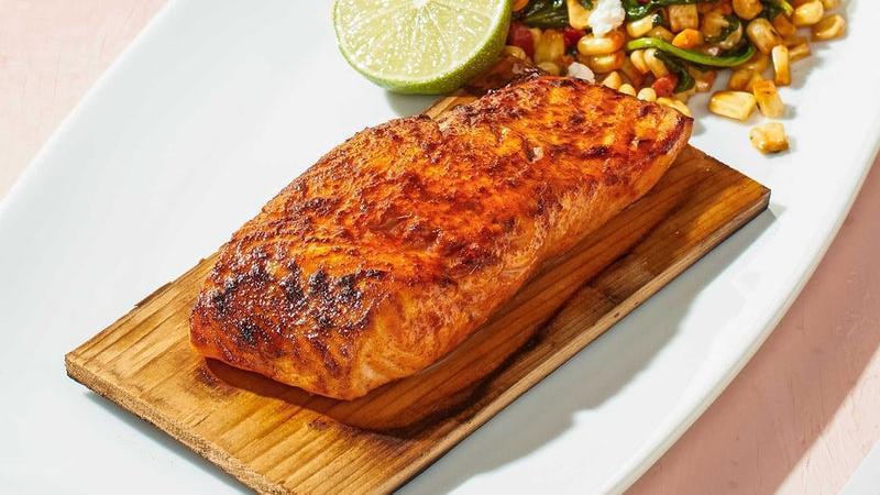 Cedar Plank Salmon* · North Atlantic salmon roasted on a cedar plank in our hearth oven with smoked paprika and lime. Served with white corn & spinach succotash topped with Feta.