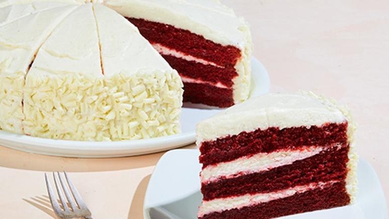 Whole Red Velvet Cake · Frosted with hand-whipped vanilla bean cream cheese and white chocolate curls.  12 Slices.