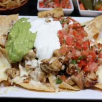 Super Nachos · Our crunchy and delicious freshly made tortilla chips, topped with your meat choice, Montere...