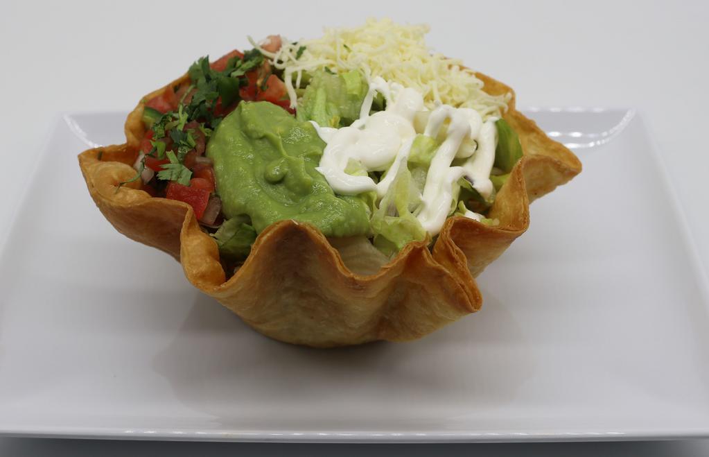  Taco Salad · Hard-shell tortilla bowl, filled with your favorite meat choice, refried beans, rice, cheese, pico de gallo, lettuce, fresh guacamole, and sour cream.