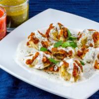 Mantu · Steamed dumplings filled with ground beef, onion and herbs, topped with meat sauce and garli...