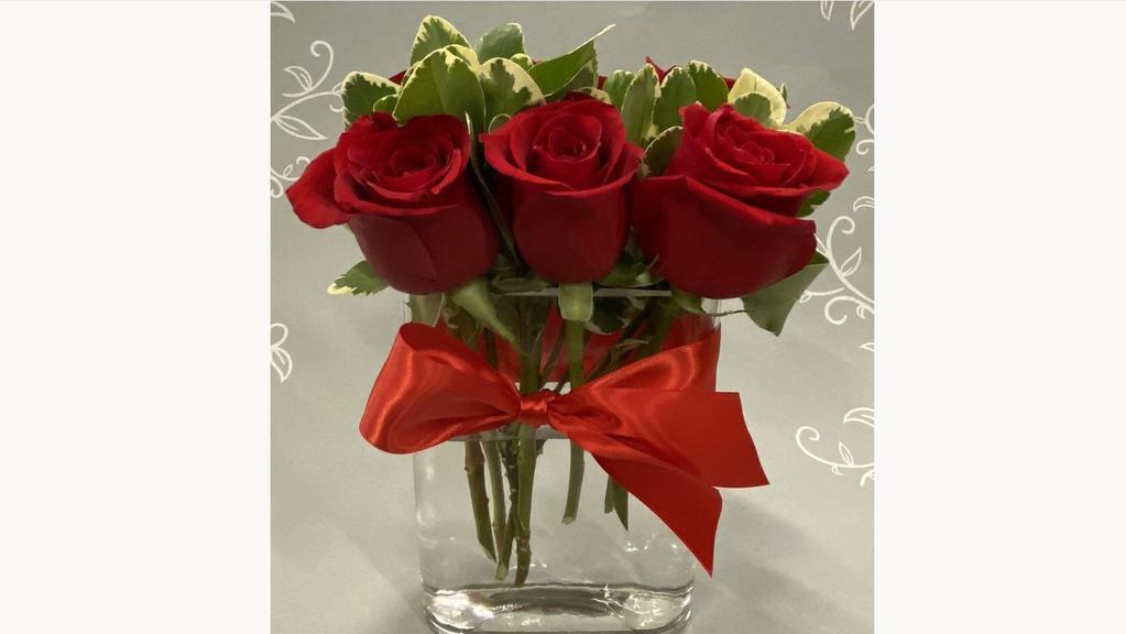 Debi Lilly Rose Mini Modern Arrangement · Roses with greens in a clear mini modern vase. Roses can be red, pink, or yellow.