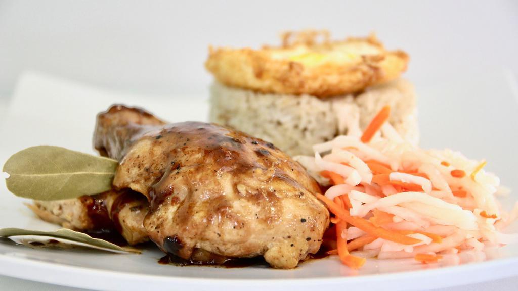 Adobo Rice Plate · Chicken or pork adobo over steamed rice served with a fried egg and pickled vegetables.