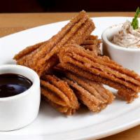 Churros · Homemade dulce de leche filled churros, whipped cream, and chocolate sauce.