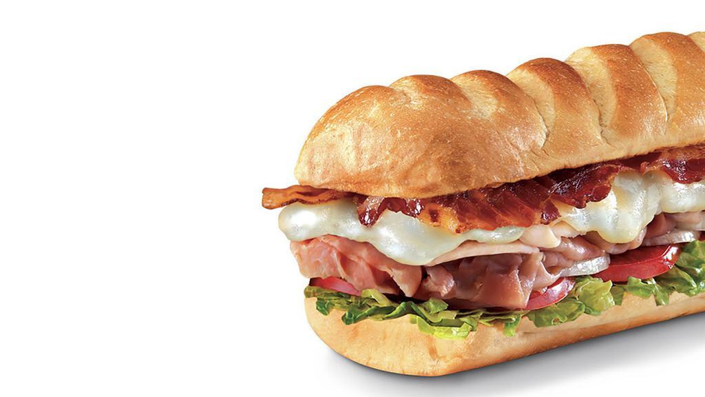 Club On A Sub™, Large (11-12 Inch) · Smoked turkey breast, Virginia honey ham, crispy pepper bacon, and melted Monterey Jack, served Fully Involved® (mayo, lettuce, tomato, onion, deli mustard, and a pickle spear on the side).