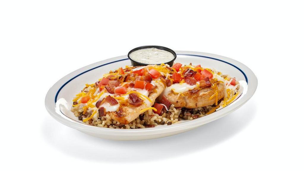 Cheesy Chicken Bacon Ranch · Two freshly grilled or buttermilk crispy chicken breasts, white cheese sauce, Jack & Cheddar cheese, diced hickory-smoked bacon, & diced fresh tomatoes served over our rice medley. Served with a side of ranch.
