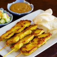 Chicken Satay · Marinated chicken on skewer with peanut sauce and cucumber salad.