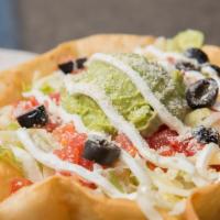 Taco Salad · Tortilla shell, refried beans, lettuce, cheese, tomatoes, sour cream, guacamole, olives.