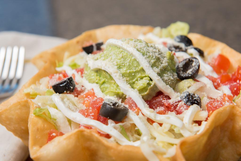 Taco Salad · Tortilla shell, refried beans, lettuce, cheese, tomatoes, sour cream, guacamole, olives.