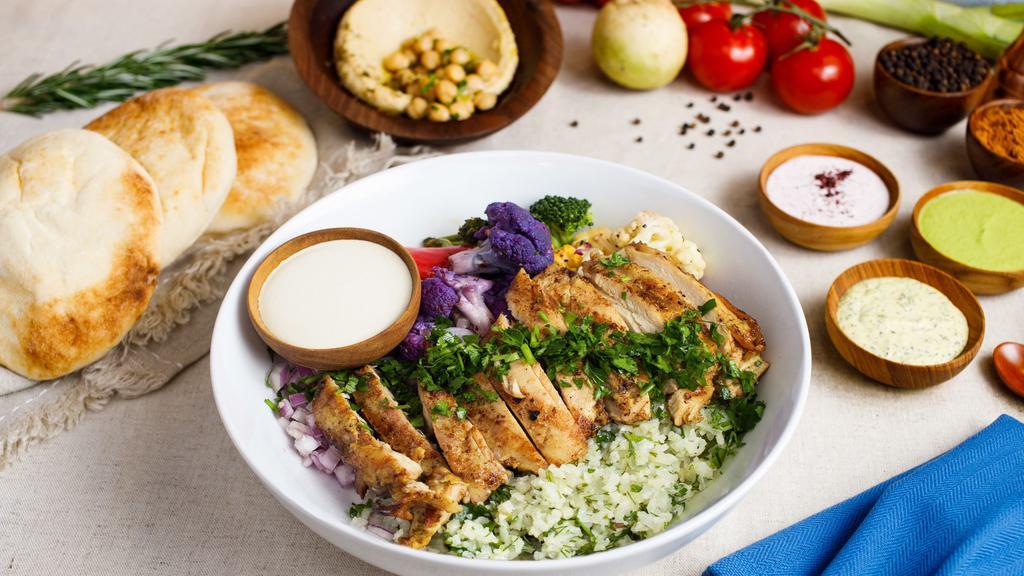 Keto Greek Chicken Bowl · Keto cauliflower rice, grilled marinated chicken, roasted vegetables, red onions, lemony tahini sauce.