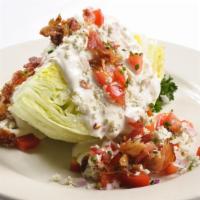 The Steakhouse Wedge · A wedge of iceberg, chopped tomato, diced red onion, crumbled blue cheese, smoked bacon, and...